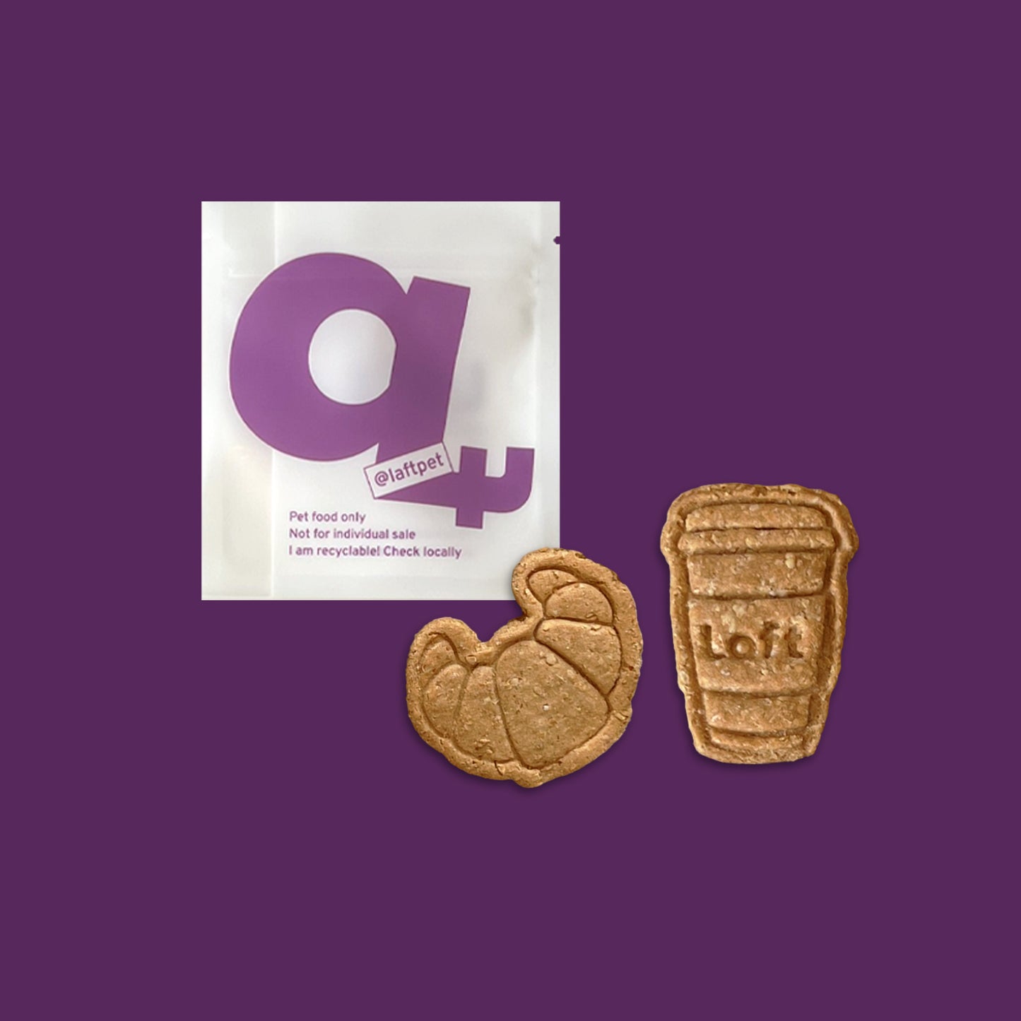 A white Laft Pet treat pouch placed next to a croissant and a takeaway coffee cup cookies on a dark purple background.