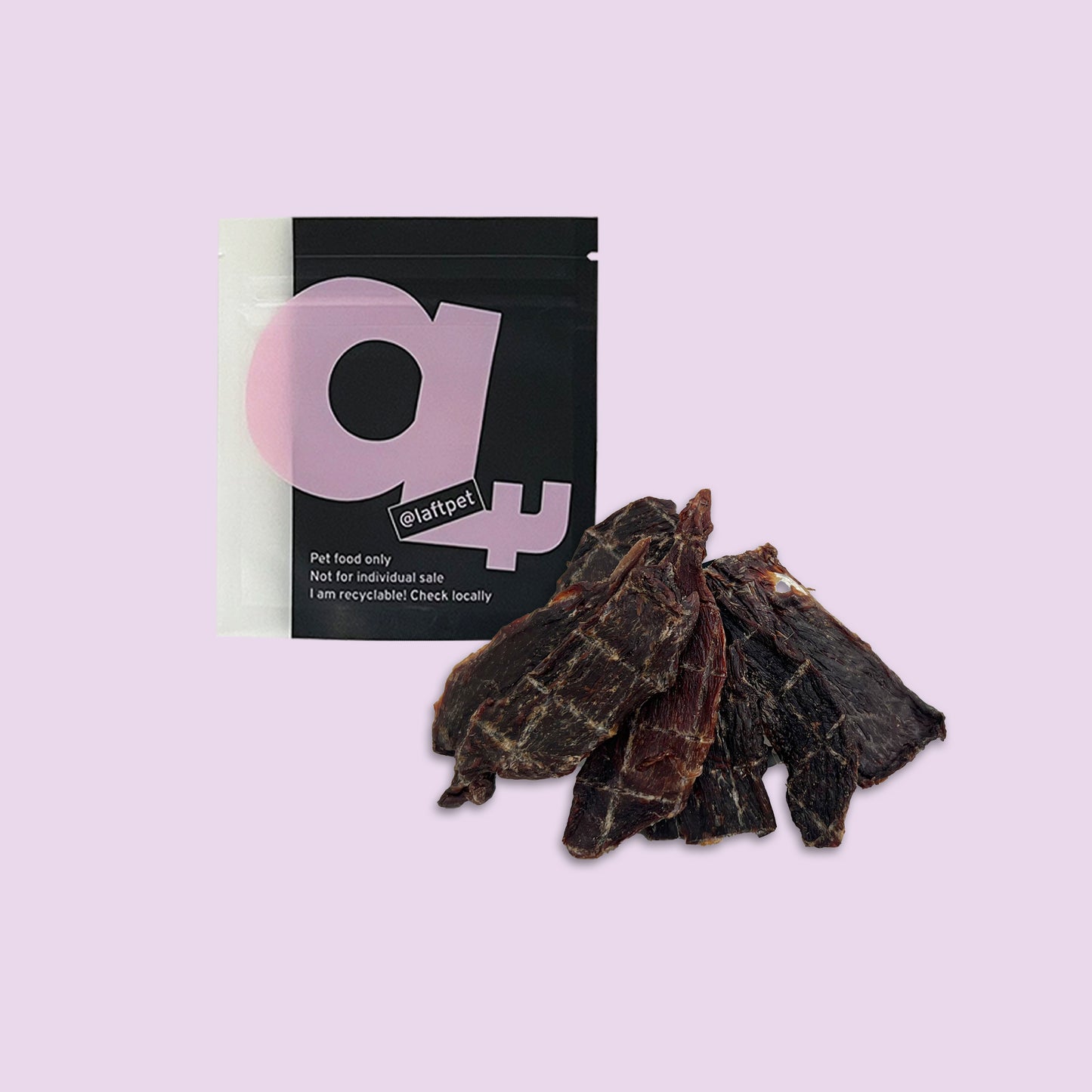 A black Laft Pet treat pouch placed next to a pile of dehydrated kangaroo jerky dog treats on a light purple background.
