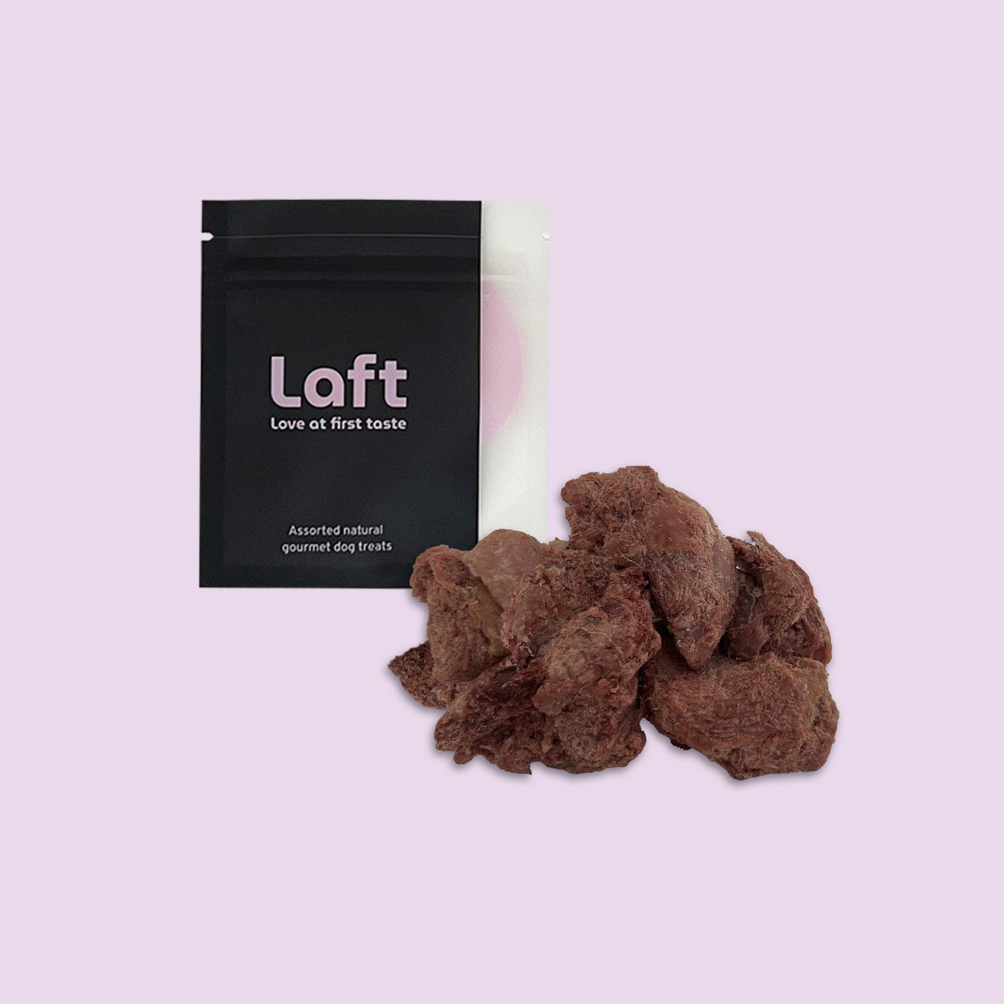 A black Laft Pet treat pouch placed next to a pile of freeze-dried wild boar dog treats on a light purple background.