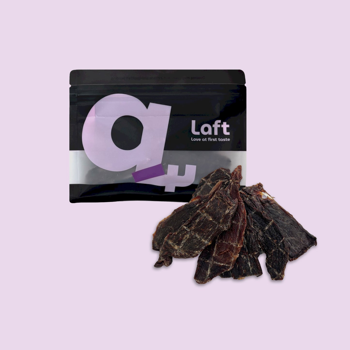 A black Laft Pet natural dog treat pouch placed next to a pile of dehydrated kangaroo jerky dog treats on a light purple background.
