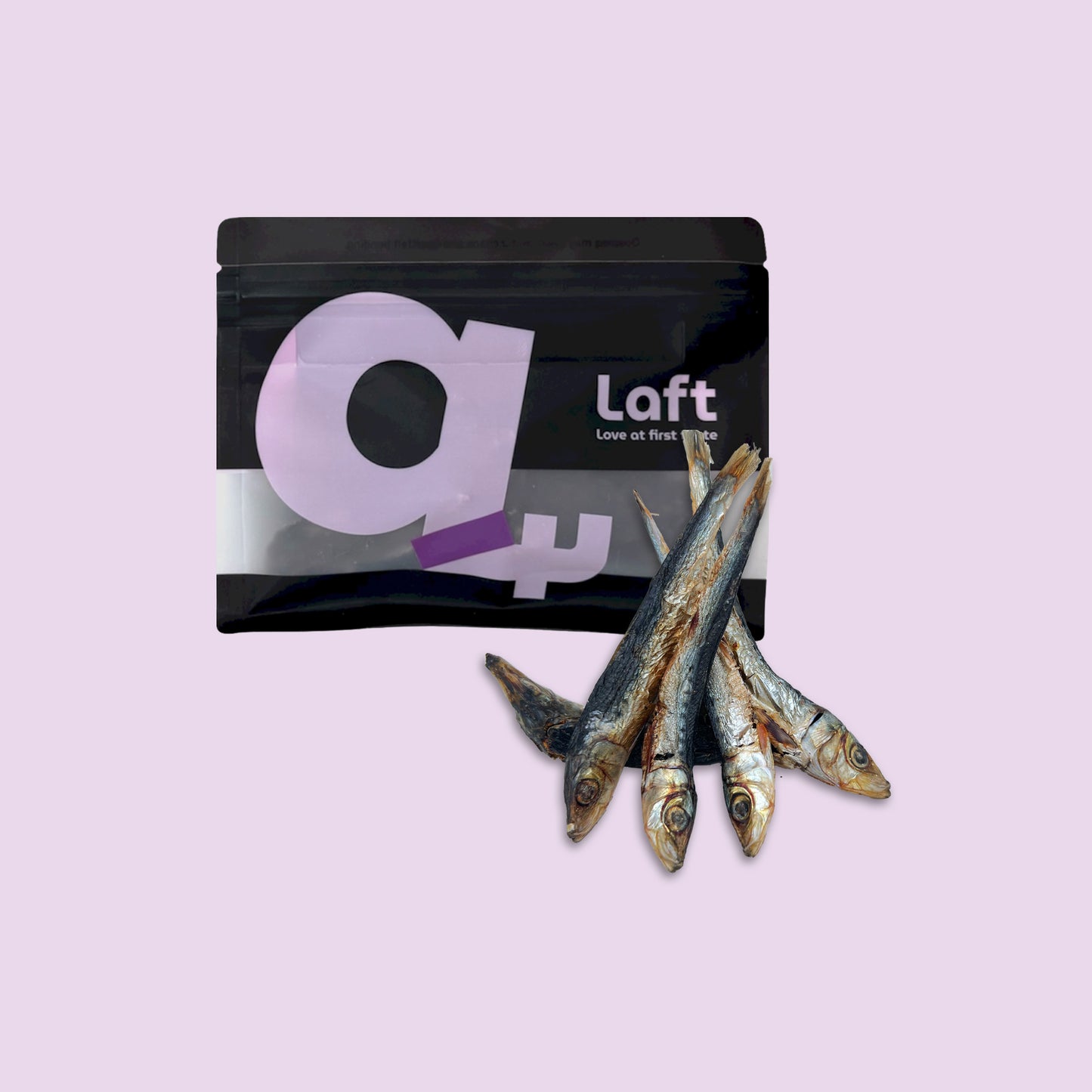 A black Laft Pet natural dog treat pouch placed next to a pile of dehydrated pilchards dog treats on a light purple background.