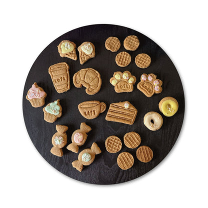 A round black serving platter displays various treats: Laft coffee cup, croissant, paw cookies, cappuccino, cake slice, cupcake, donut, ice-cream cone, lolly and waffle.