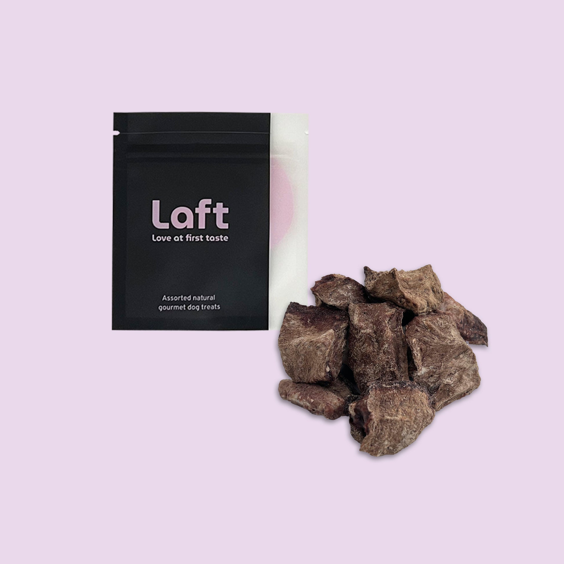 A black Laft Pet natural dog treat pouch placed next to a pile of freeze-dried beef heart dog treats on a light purple background.