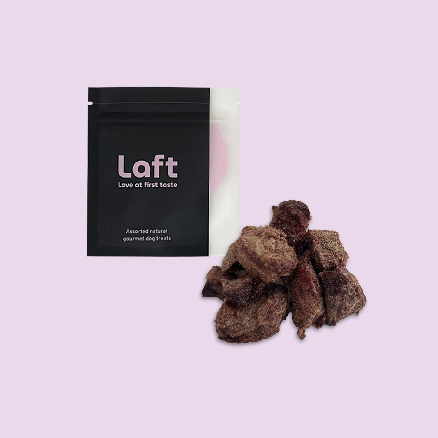 A black Laft Pet natural dog treat pouch placed next to a pile of freeze-dried emu dog treats on a light purple background.