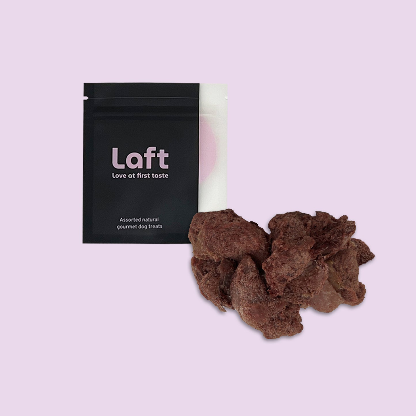 A black Laft Pet natural dog treat pouch placed next to a pile of freeze-dried venison dog treats on a light purple background.